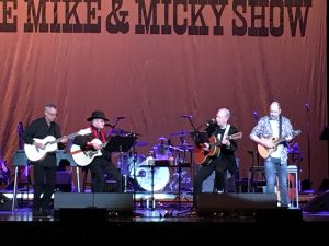 Mike Nesmith and Micky Dolenz in concert, flnaked by lead guitarist left and Christian Nesmith right.